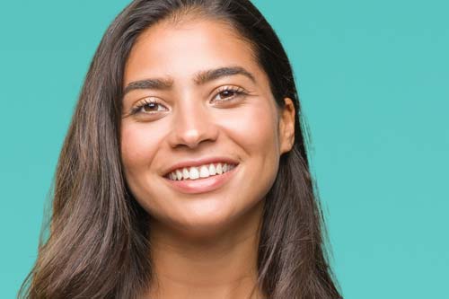 cosmetic dentistry woman smiling teal backdrop