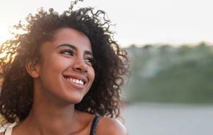 woman smiling at a lake in Houston after general dentistry meyerland plaza tx