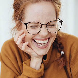 woman laughing with eyes closed showing off clean teeth from general dentistry at meyerland plaza