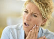 woman holding her cheek in pain from tooth ache and not learning how to prevent tooth decay for tooth decay prevention