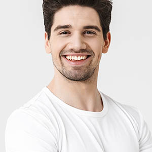 man in white smiling to show off teeth whitening from lovett dental meyerland plaza