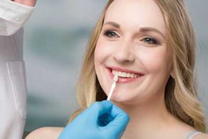 dentist cleaning woman's teeth during dental veneer services tx to prepare them for dental veneers tx