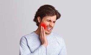 a man struggles with a dental emergency