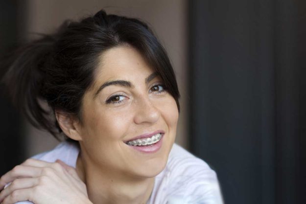 5-Signs-You-Need-Dental-Braces-Again a woman smiles with her dental braces